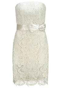 Utan axelband, klänning i elfenbenstint spets med blommönster, en åtsittande silhuett och ett satinbälte med en sløyfe i midjan. Sicksackdetalj i nederkanten.