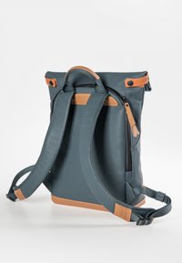 Blauwe roll-top rugzak met leren accenten, verstelbare banden en een ritsvak. Houten textuur en gestroomlijnd ontwerp.