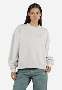 Light grey oversized sweatshirt with a crew neckline, ribbed cuffs, and hem, featuring a small white "Pegador" logo on the front.