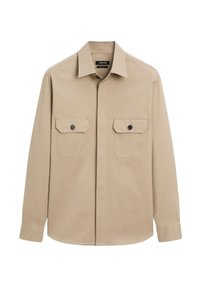 Camicia beige con bottoni in cotone, dotata di colletto, maniche lunghe e due tasche sul petto con bottoni neri. Tessuto liscio.