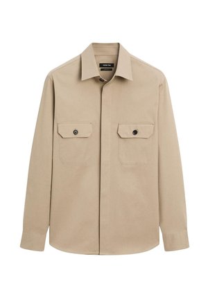 Chemise beige à manches longues en coton, dotée d'un col et de deux poches poitrine avec des boutons noirs. Texture lisse.
