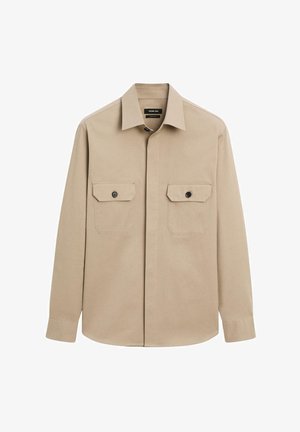Camicia beige con bottoni in cotone, dotata di colletto, maniche lunghe e due tasche sul petto con bottoni neri. Tessuto liscio.