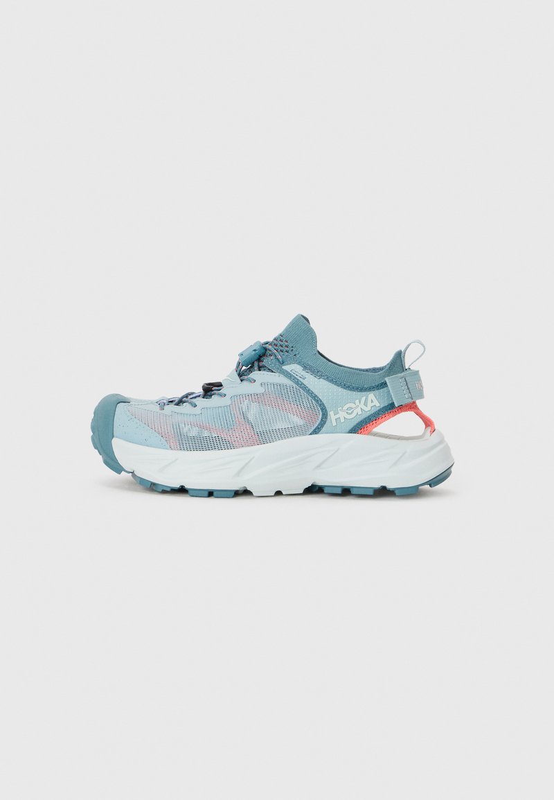 Baskets de course bleu clair avec une tige en mesh respirant, semelle en caoutchouc et talon large. Équipées de lacets élastiques et d'une languette à l'arrière.