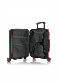 Hard-shell luggage in deep burgundy, featuring black interior with mesh pockets, zipper compartments, and a retractable handle. Four rolling wheels.