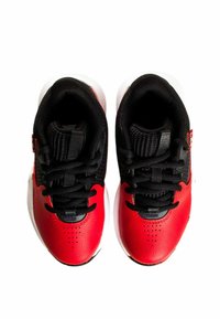 Zapatillas deportivas rojas y negras con una parte superior de cuero texturizado, cierres de cordones y suelas de caucho blancas. Diseñadas para la comodidad y el soporte.