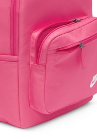 Ροζ σακίδιο με υφή υφάσματος, διαθέτει δύο με zip τσέπες και λευκό λογότυπο. Συμπαγής σχεδίαση με ενισχυμένες ραφές για αντοχή.