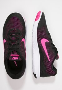 Černé a růžové atlety mají síťovaný svršek, šněrování a bílou podrážku s texturovanými detaily. Logo v růžové barvě po stranách.