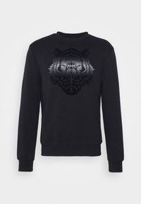 Sudadera negra con un gráfico de tigre en tonos de gris, con un cuello redondo y mangas largas, hecha de un tejido suave.
