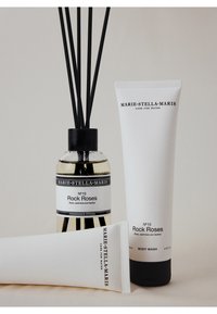 Trois produits Marie-Stella-Maris Rock Roses : un diffuseur en verre avec des tiges noires, un tube blanc de gel douche et un tube blanc de crème, tous étiquetés.