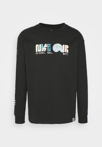 Svart långärmad t-shirt i bomull med färgglada Nike-logografik på framtill och ärmen; standard passform med rund halsringning.