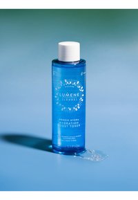 Blauwe plastic fles met witte dop, gelabeld "LUMENE NORDIC HYDRA Hydration Boost Toner," met een cirkelvormig grafisch ontwerp en vloeistofspetters.