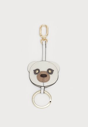 Porte-clés avec un design d'ours en cuir texturé, en crème et marron, avec des accessoires en métal doré et un anneau de clé rond.