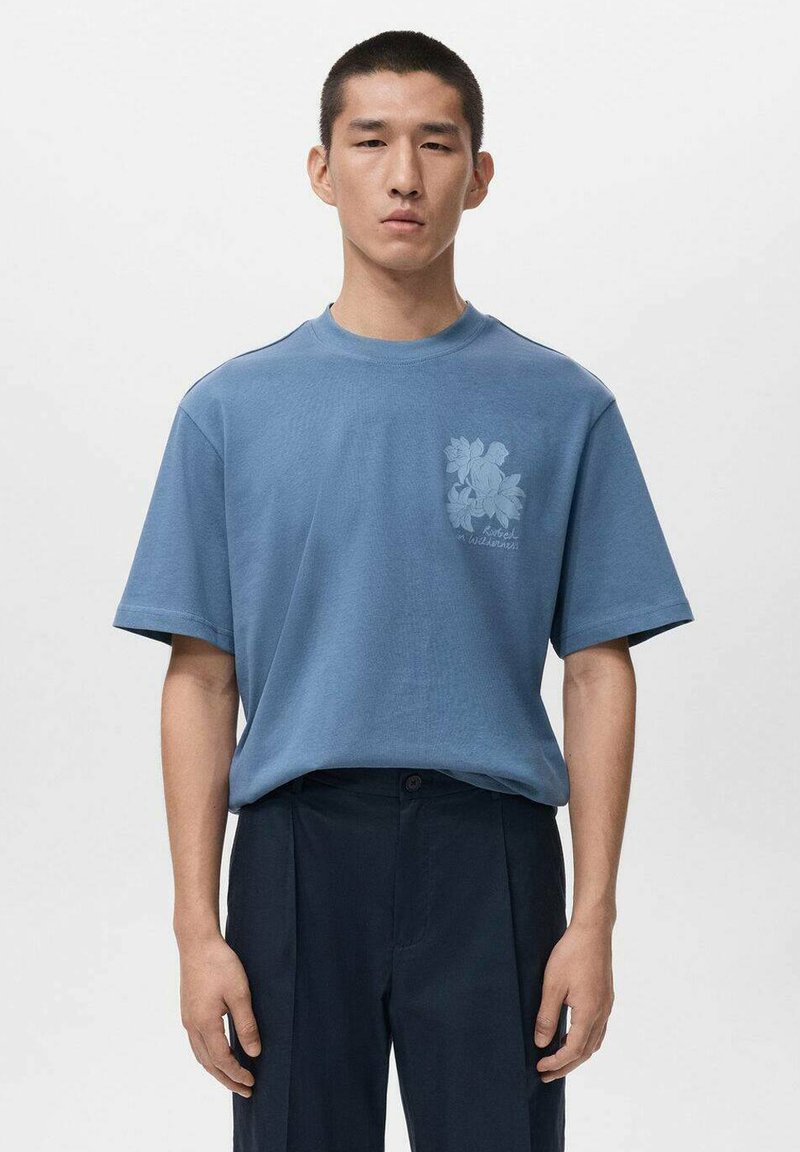 Niebieska bawełniana koszulka z krótkimi rękawami, z kwiatowym wzorem w jasnym niebieskim na klatce piersiowej. Prosty krój, okrągły dekolt, gładka faktura.