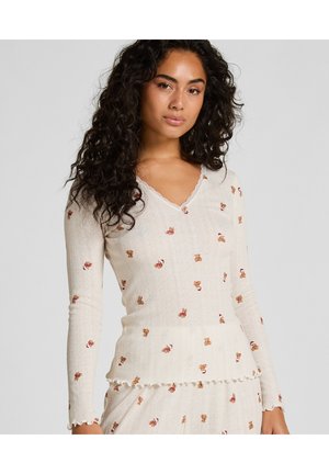 T-shirt à manches longues en crème, avec un col en V et un ourlet festonné. Décoré de motifs d'ours en peluche et d'un tissu texturé à côtes.
