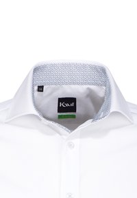 Camicia bianca con colletto strutturato. L'interno del colletto presenta un rivestimento a motivo blu. Etichetta con taglia 38 visibile. Texture liscia e vestibilità slim.