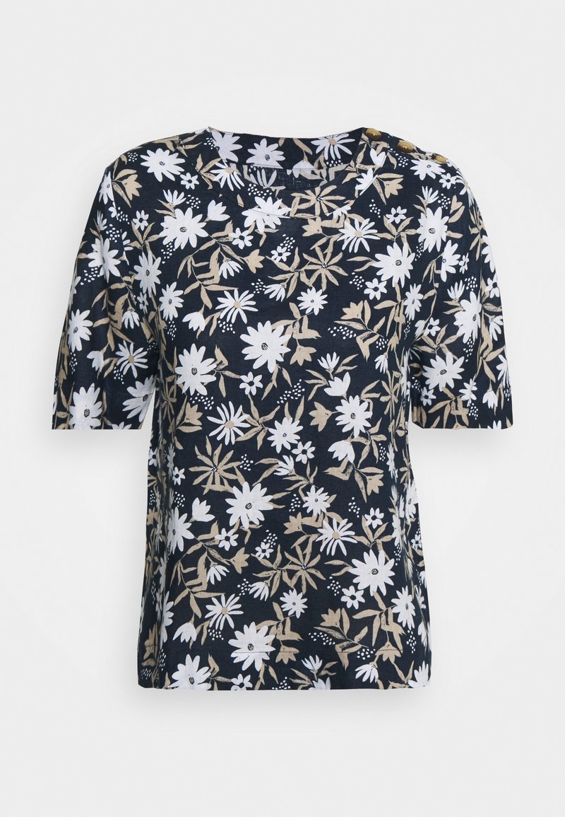 Chemise bleu marine à manches courtes avec motif floral blanc et beige et deux boutons dorés sur l'épaule gauche.