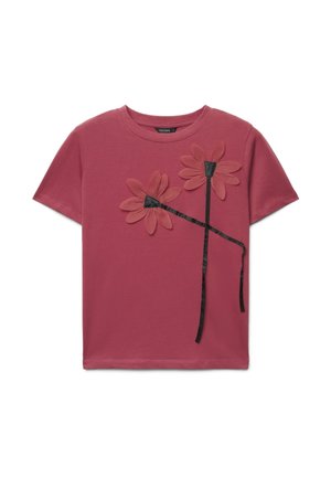 T-shirt mauve à manches courtes avec deux grandes fleurs en tissu et des tiges en ruban noir sur le devant.