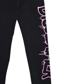 Leggings neri aderenti, con un audace design di testo rosa gocciolante lungo la gamba sinistra. Tessuto morbido ed elastico per il massimo comfort.