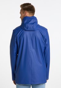 Blauwe waterdichte jas met een capuchon, gemaakt van glad, glanzend materiaal. Heeft een rechte snit en lange mouwen, met minimale details.