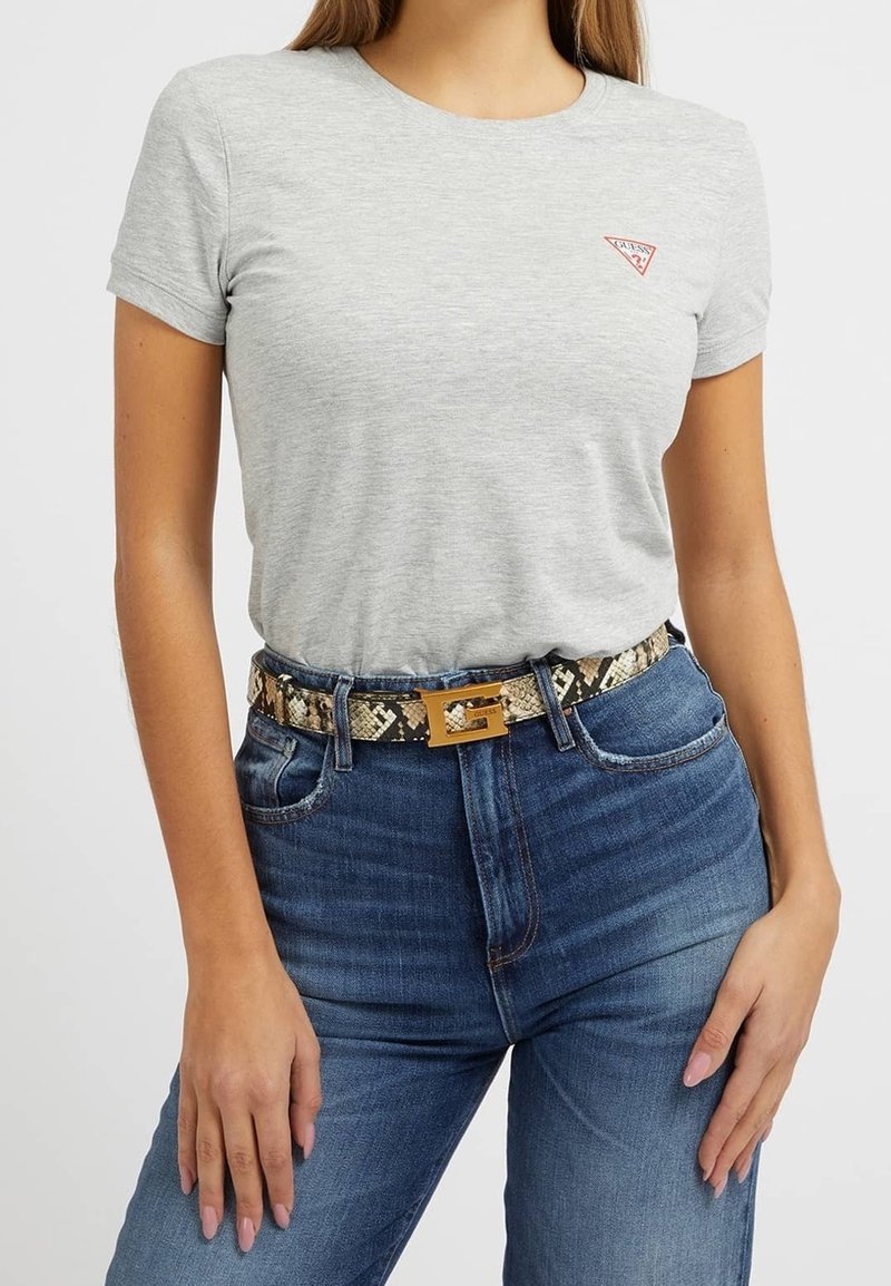 T-shirt grigio a maniche corte con logo a triangolo rosso, abbinato a jeans blu a vita alta e una cintura pattern con fibbia dorata.