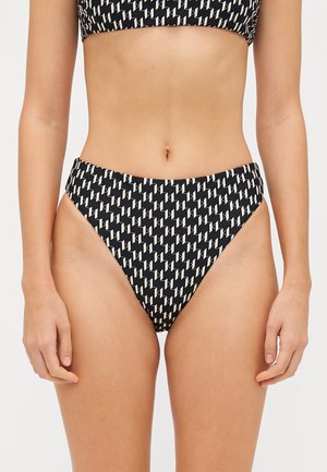 Svart och krämfärgad mönstrad bikini med högmidjade underdelar och geometrisk design. Tyget ser slätt ut med en lätt glans.
