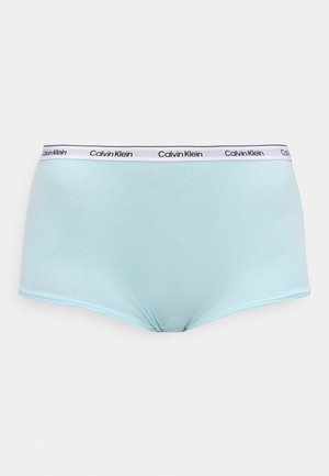 Hele sinine naiste puuvillane aluspesu valge elastse vöökohaga, millel on musta tekstiga "Calvin Klein" logo.