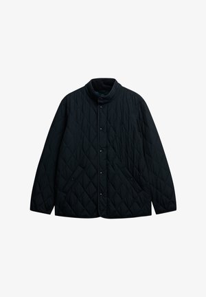 Veste noire matelassée avec boutons-pression, col montant et deux poches avant, présentée sur un fond blanc.