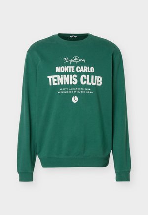Sweatshirt vert à manches longues avec texte blanc "Björn Borg Monte Carlo Tennis Club" et un petit graphique de balle de tennis à l'avant.