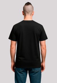 Black cotton t-shirt with short sleeves, round neckline, and a simple design. Worn by a person, showing a clean back view.