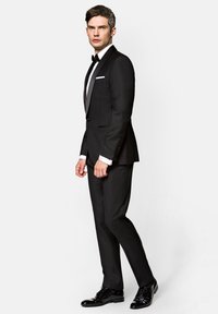 Czarny frak z satynowym, szpiczastym kołnierzykiem, biała koszula i czarny muszka. Posiada dopasowane spodnie i błyszczące czarne buty wizytowe.