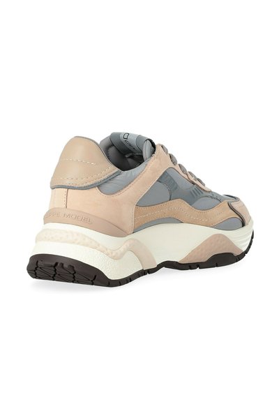 Sneaker beige et gris avec semelle blanche épaisse, semelle noire, panneaux en daim et cuir, et marque "Philippe Model" sur le talon.