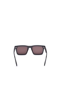 Lunettes de soleil noires à monture rectangulaire avec verres teintés foncés présentées sur fond blanc.