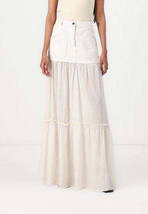 Long skirt in cream color con un top strutturato e due tasche frontali, realizzata in un materiale simile al denim, con una parte inferiore a strati fluida.