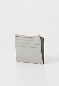 Portafoglio in pelle grigia, forma rettangolare, superficie testurizzata, chiusura con zip in cima, quattro slot per carte sul fronte, design minimale, cuciture sottili.