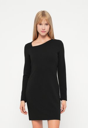Robe noire à manches longues avec un décolleté asymétrique. Design ajusté, texture lisse et longueur au-dessus du genou.