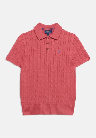 Polo rose à manches courtes en maille torsadée, avec col, trois boutons et petit logo brodé sur la poitrine gauche.