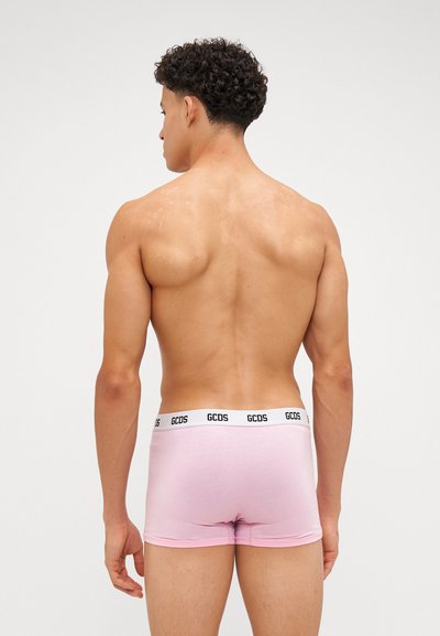 Boxer brevissimi rosa con una vita elastica bianca e nera con logo, caratterizzati da una texture liscia e un design aderente.