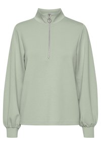 Sudadera verde claro con cuello alto y cierre plateado de cremallera hasta un cuarto. Presenta mangas largas ligeramente fruncidas y una textura suave.