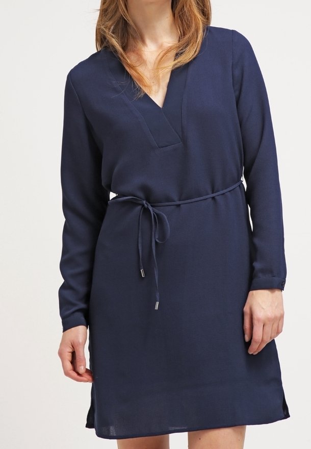 Vestido azul marino hecho de tela ligera, con mangas largas, escote en V y cinturón de lazo en la cintura. Textura suave con aberturas laterales.