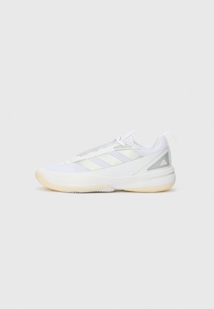 Sneaker de sport blanc à tige basse avec semelle beige, dessus en tissu mesh, trois bandes blanches sur le côté et fermeture à lacets sur fond gris.