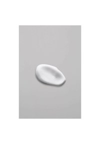 White foam texture with small bubbles, shaped like an oval, on a smooth gray surface. Consistent color with a soft, creamy appearance.