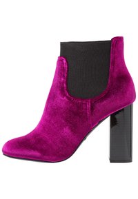 Botín de tobillo de terciopelo fucsia con panel lateral de elástico negro, punta afilada y tacón en bloque negro brillante. Textura suave y diseño sin costuras.