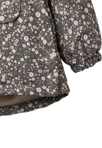 Kukkaprintti-kuvioitu takki tummasta kankaasta, jossa on pehmeät, kerätyt hihat ja helmassa ylellinen sisävuoraus.