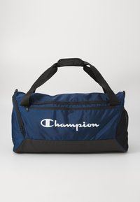 Mørkeblå duffelbag med sort bund, lynlåskompartments og meshsidelomme; har hvide "Champion" logo på fronten.