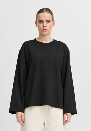 Sweatshirt noir à manches longues avec une coupe décontractée, encolure ronde et épaules tombantes, fabriqué en tissu doux avec des détails de couture minimaux.
