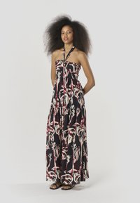 Vestido largo con base negra, con un patrón abstracto en blanco y rojo, diseño sin tirantes y una silueta fluida.