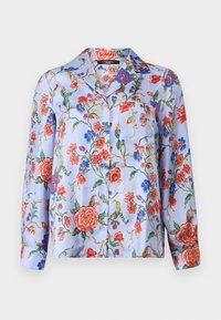 Blouse à imprimé floral bleu avec des fleurs rouges et bleues, texture soyeuse, manches longues, devant à bouton et une poche sur la poitrine.
