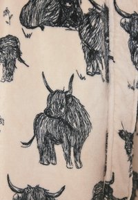 Fekete vázlatstílusú rajzok bozontos hosszúszarvú tehenekről lágy, világos rózsaszín anyagon, jobb oldalon látható varrással.