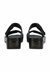 Sandalias negras con dos correas ajustables; suela texturizada, punta redondeada y un tacón grueso. Material suave con un acabado brillante.