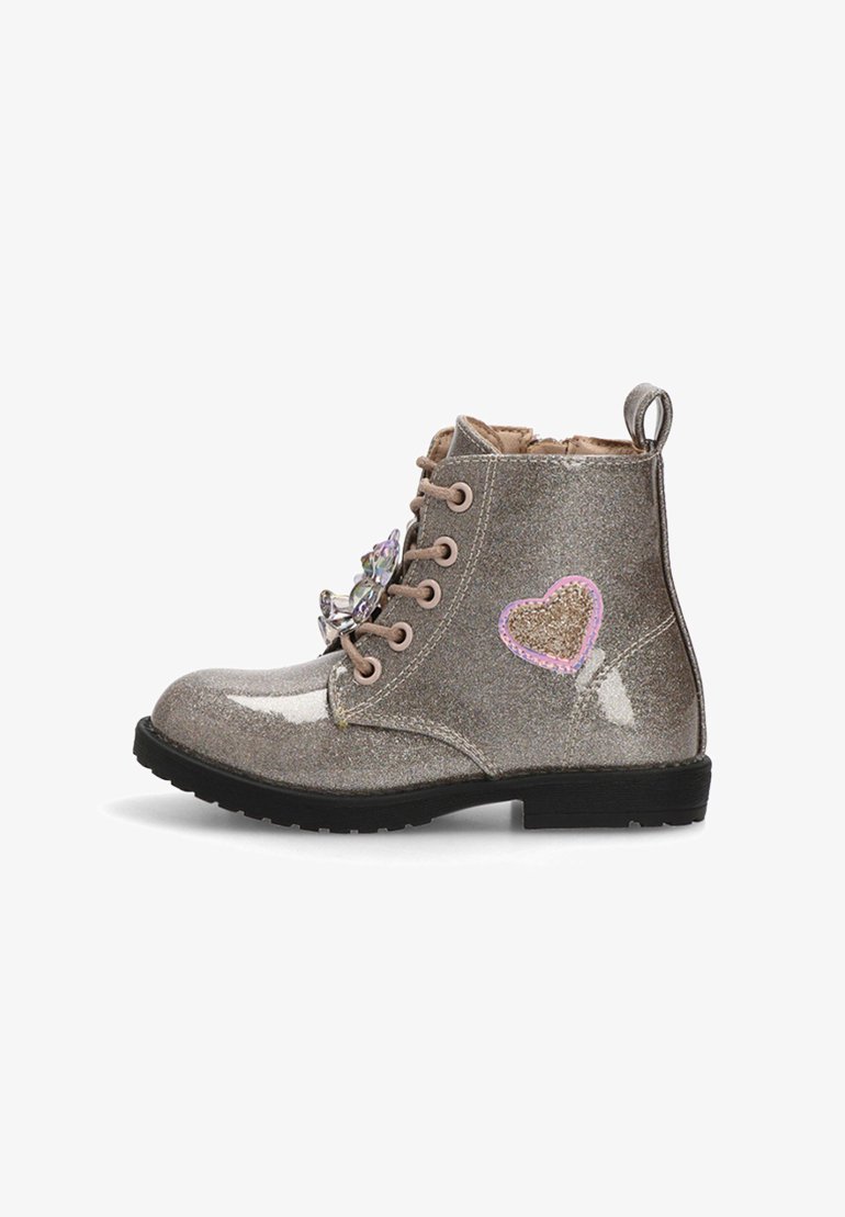 Bota de tobillo plateada brillante con cordones rosas, adornos en forma de corazón y un acabado texturizado. Suela de goma negra y lazo en el tobillo para facilitar el uso.